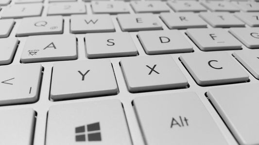 Close-up of a white computer keyboard with clearly visible keys, including letters, Alt, and the Windows logo key.