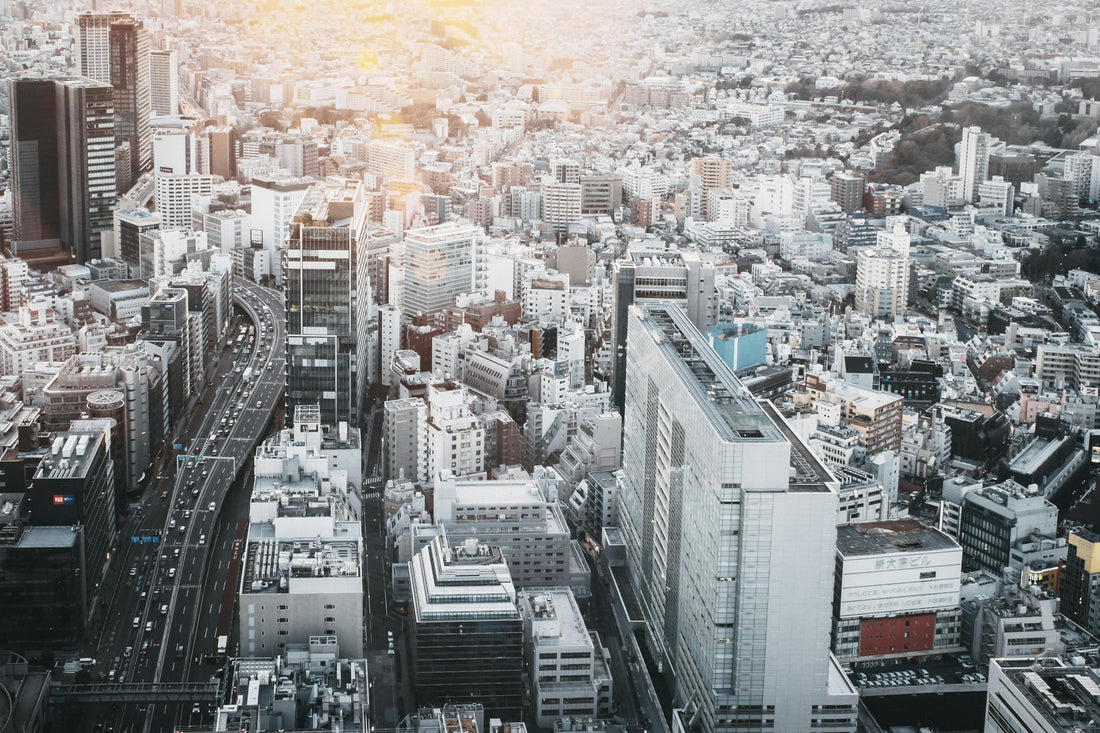 Aerial view of Shibuya, Tokyo, featuring modern buildings, busy highways, and a blend of urban and green spaces.