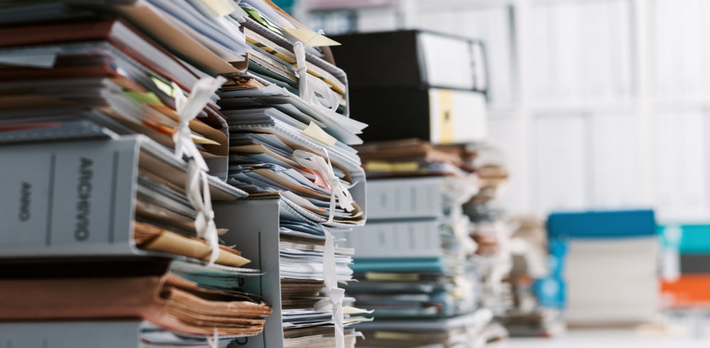 Stacks of documents on an office desk.